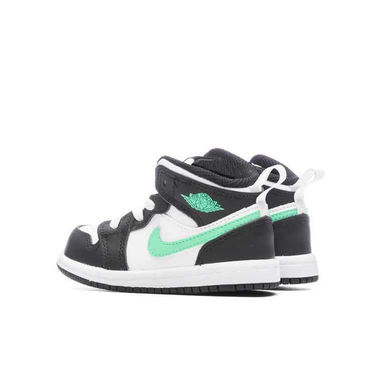 Black and white sneakers with green accents on a white background
